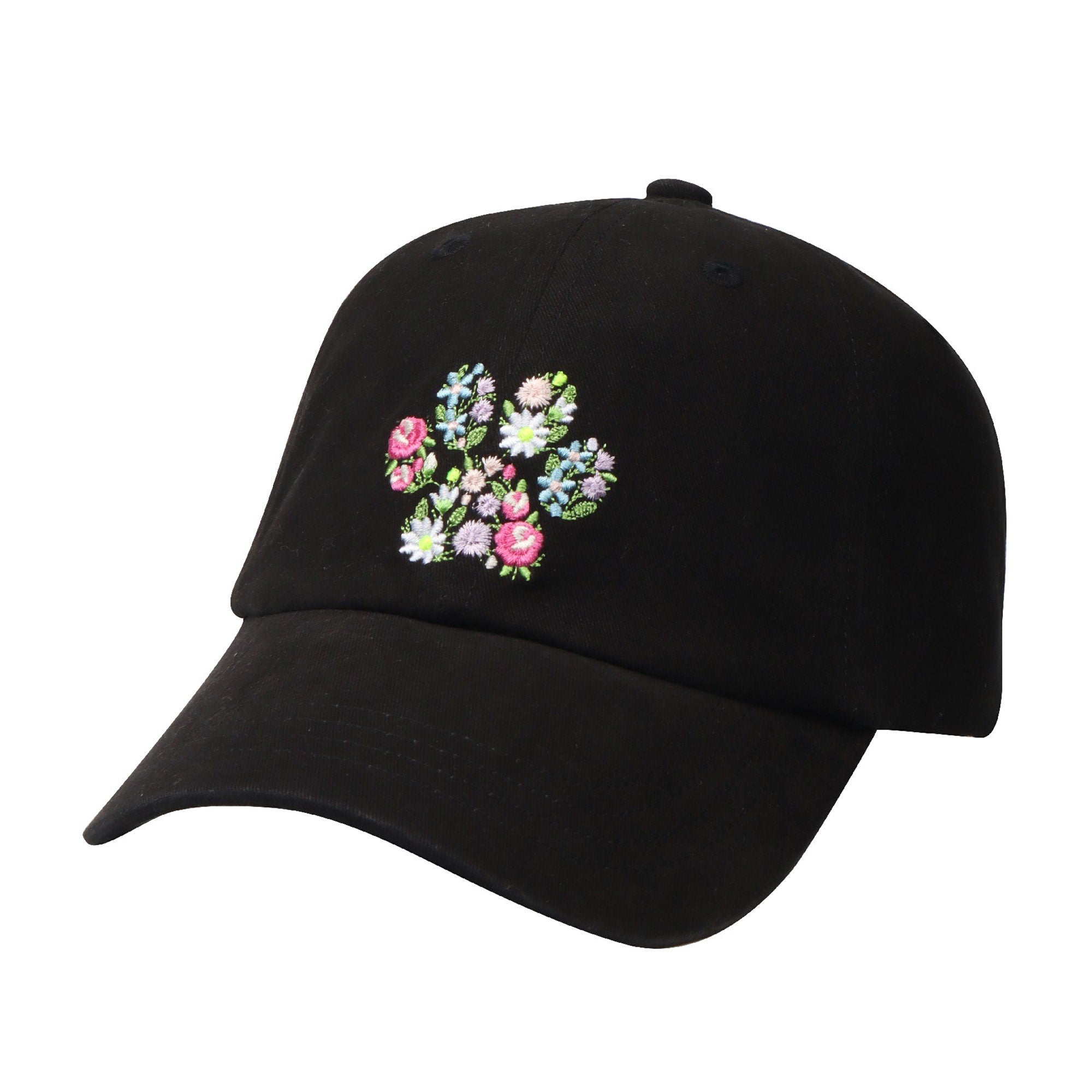 May include: A black baseball cap with a floral embroidery design in the shape of a paw print. The flowers are pink, blue, and white.